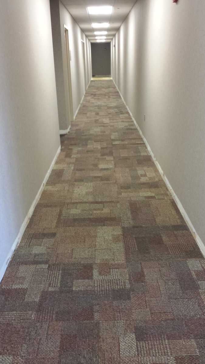 Square carpet tiles installed across a large open room