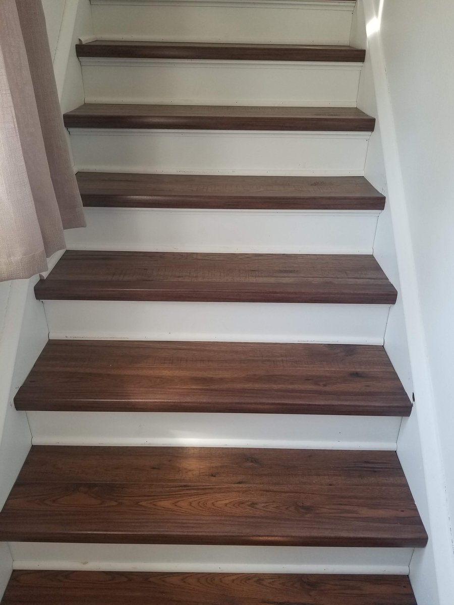 Light natural laminate flooring installed on a staircase, viewed from the bottom